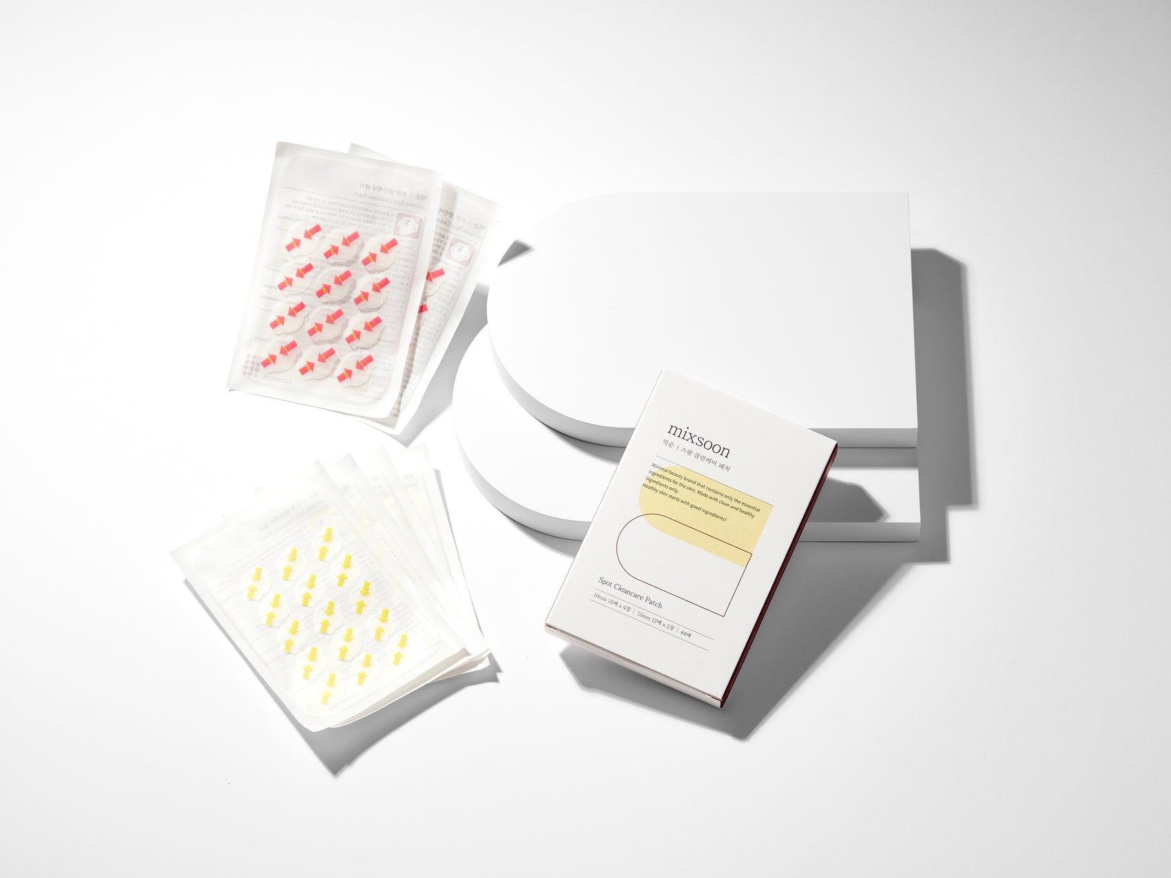 Drei transparente Beutel mit Patches und eine Produktverpackung. Auf weißem Hintergrund. Produktname: MIXSOON Spot Clean Care Patch.