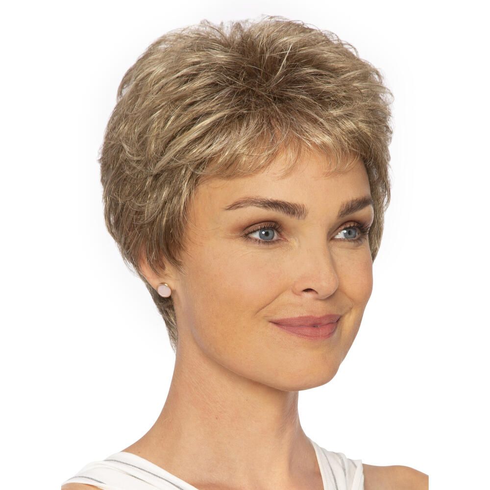 Kurzhaarperücke in Blondtönen. Frontale Ansicht einer Frau, die die Perücke trägt. Die Perücke hat einen Pony.