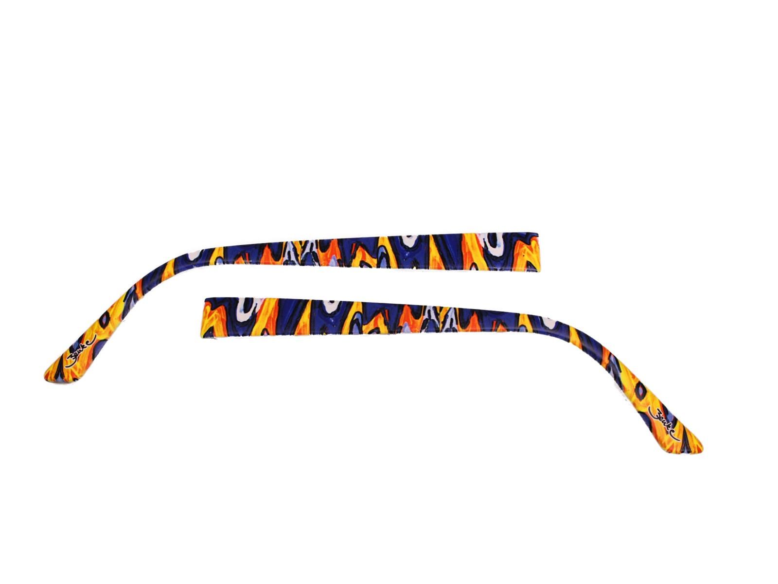 Zwei Wechselbügel für Brillen. Sie sind mit einem bunten Muster aus Blau, Orange und Gelb bedruckt. Die Bügel sind gebogen.