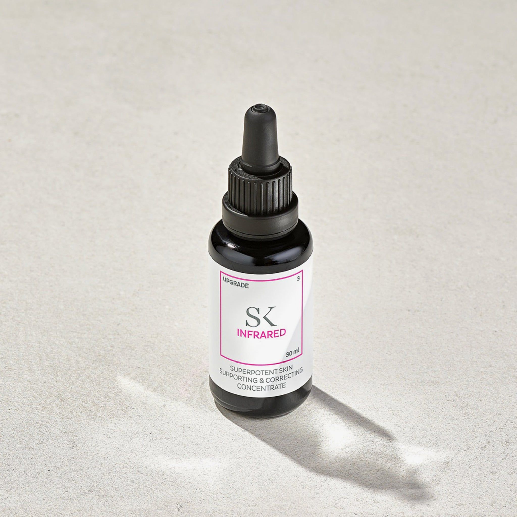 Schwarze Flasche mit Tropfer. Etikett mit "SK INFRARED" und Text. 30 ml. Produktname und Text sind rosa umrandet. Auf hellem Untergrund.