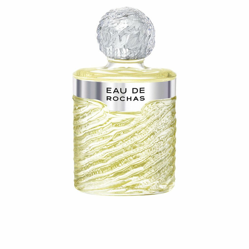 Parfümflasche mit silbernem Band, Aufschrift "EAU DE ROCHAS". Klarglasflasche mit wellenförmiger Textur. Kappe mit kugelförmigem Design.