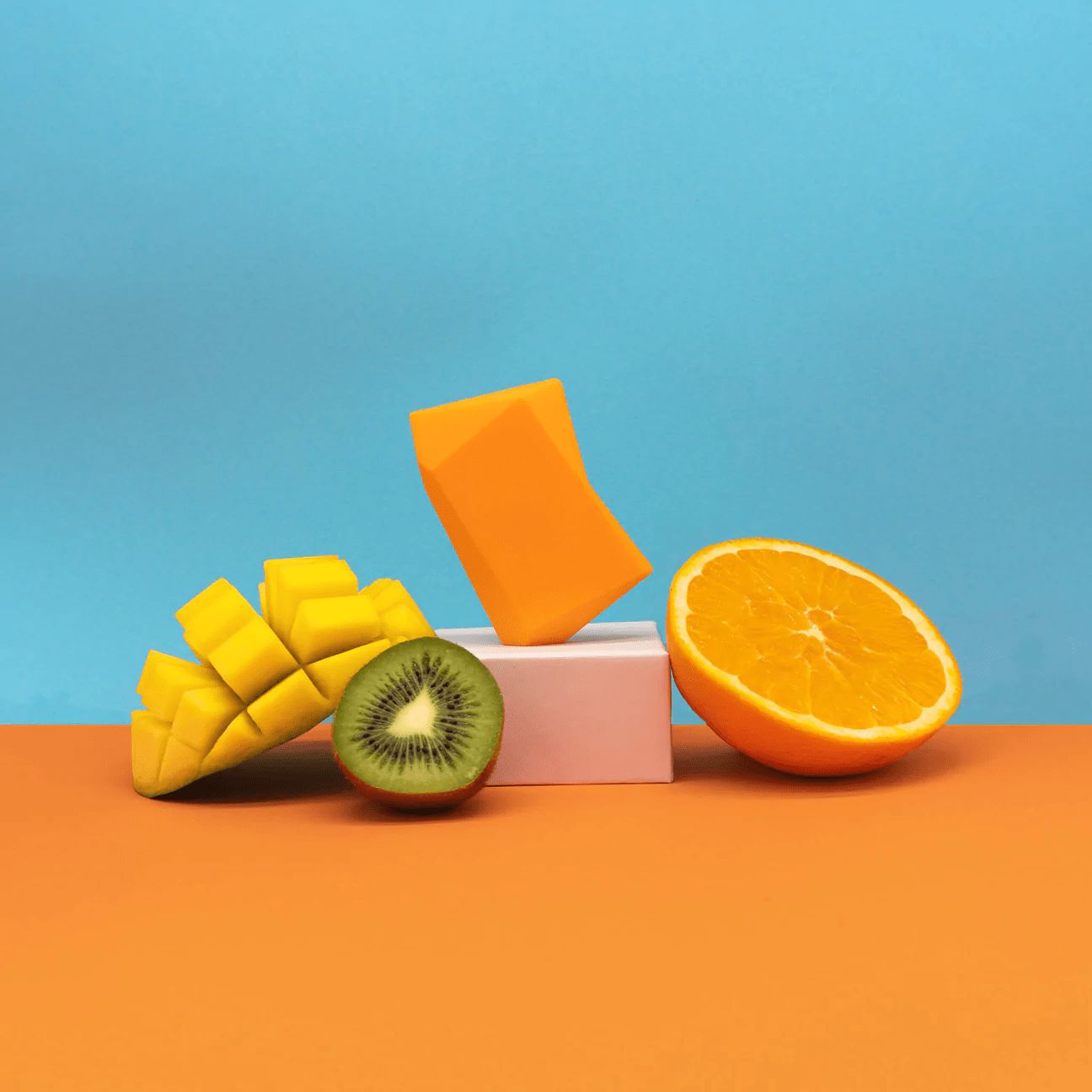 Orangefarbene Seife, Mango, Kiwi und Orange auf orange-blauem Hintergrund.