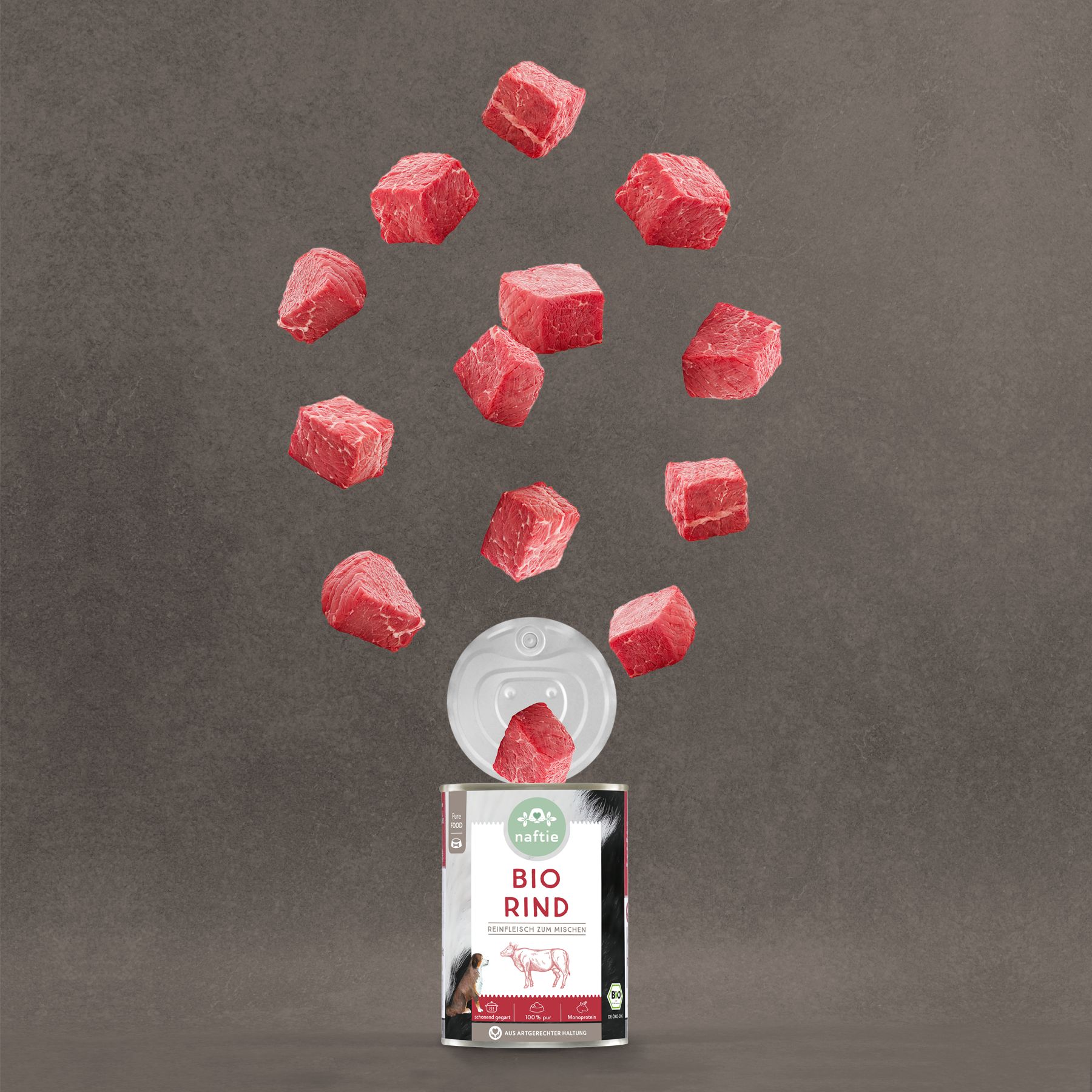 Naftie Bio-Rind Dose mit geöffnetem Deckel. Rindfleischwürfel schweben. Produktetikett mit Kuh-Illustration.