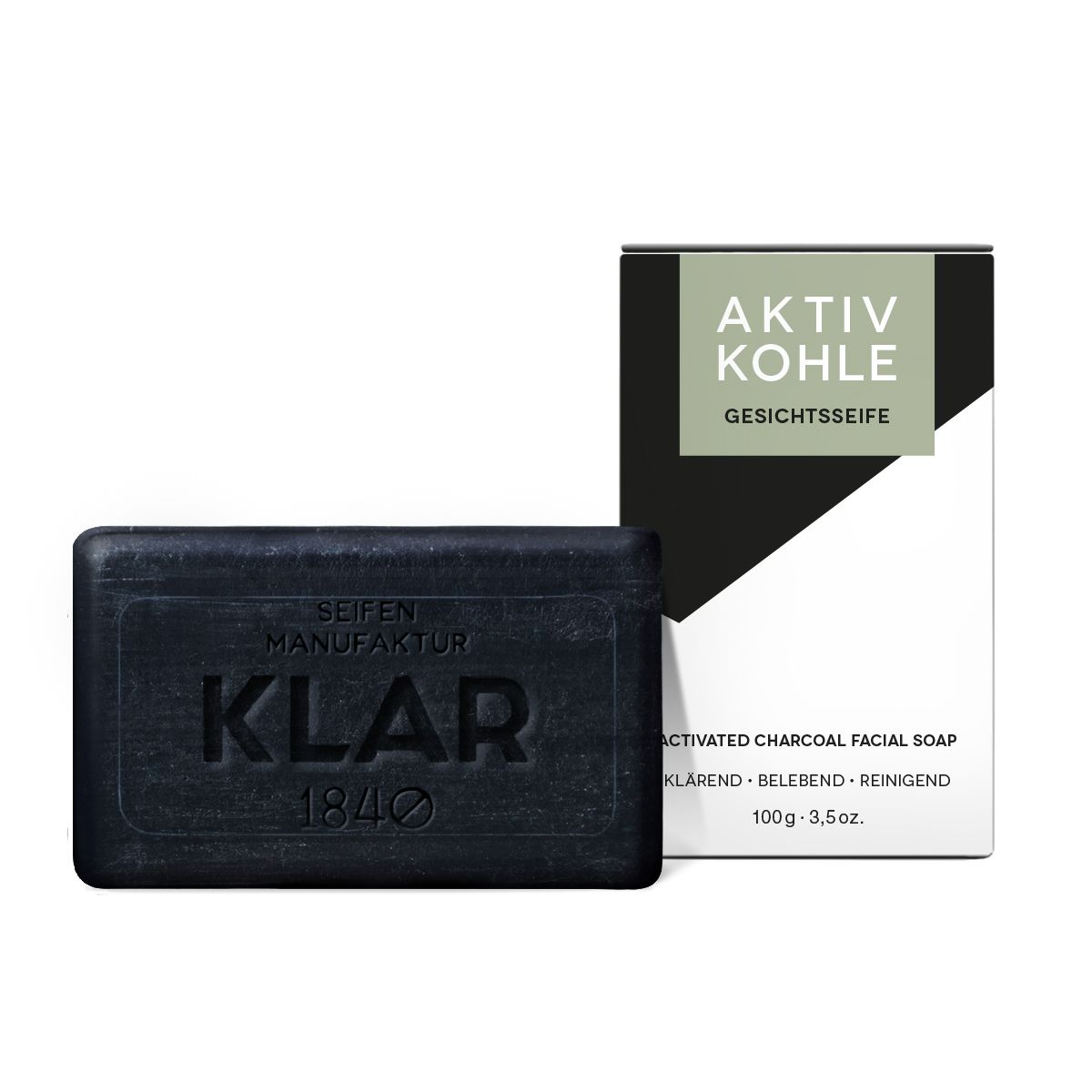 Schwarze Seife und Verpackung. Auf der Seife steht "KLAR" und "SEIFEN MANUFAKTUR 1840". Die Verpackung trägt "AKTIV KOHLE GESICHTSSEIFE".