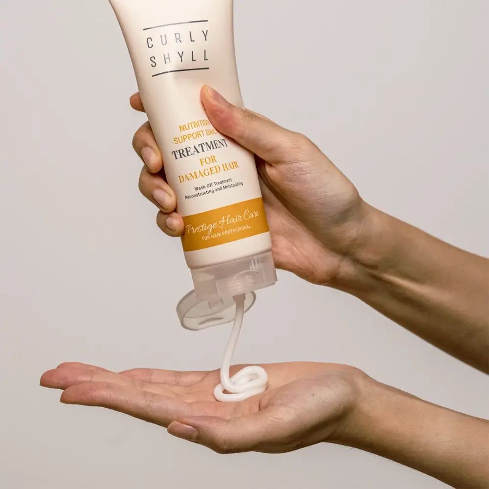 Tube mit Produktnamen und Text. Creme wird in die Hand gedrückt. Helle Haut.