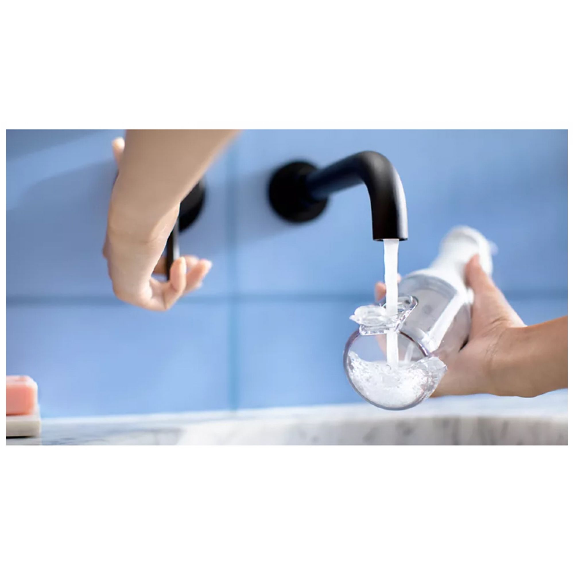 Wasser wird in den Tank der Munddusche gefüllt.