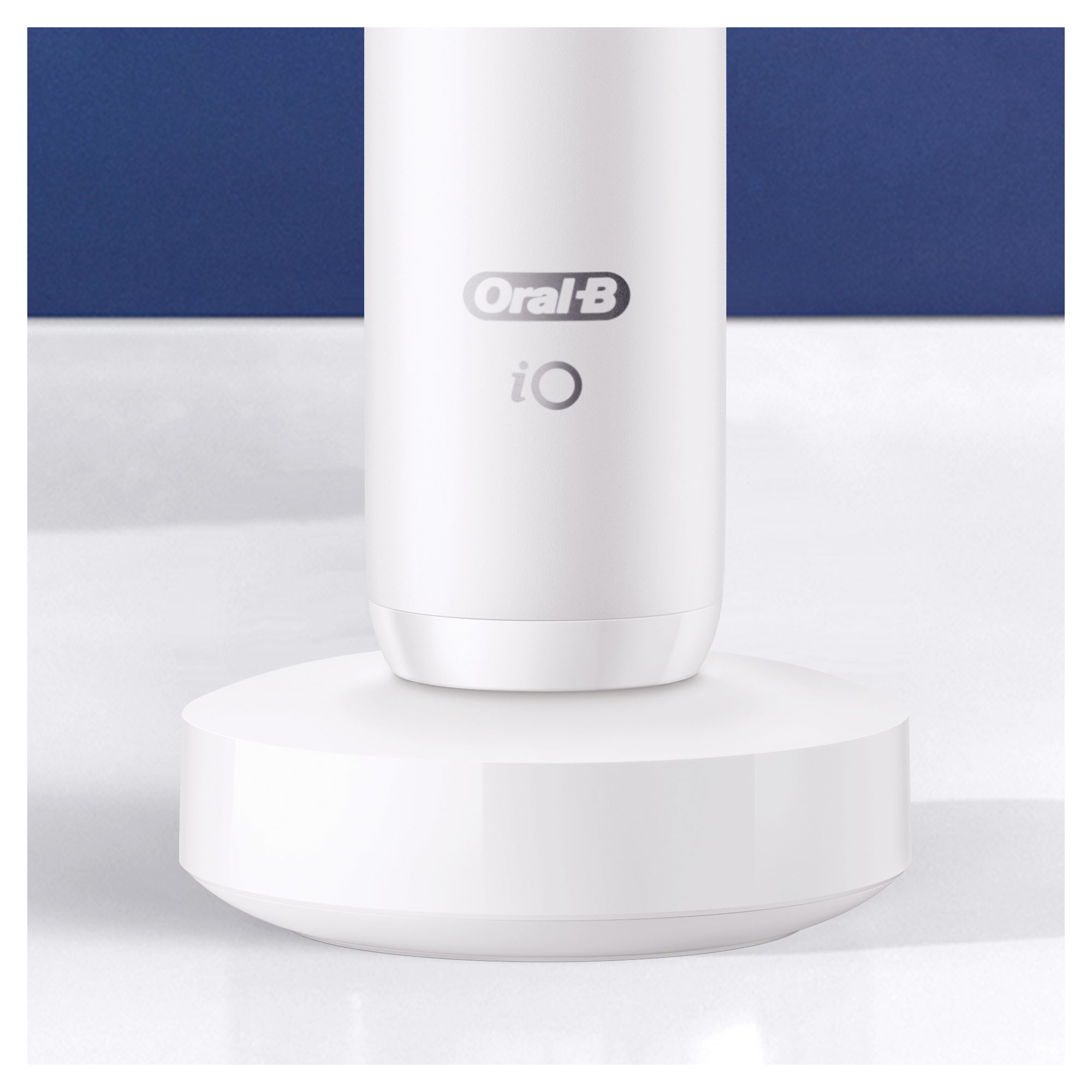 Nahaufnahme der weißen Ladestation der elektrischen Zahnbürste iO. Oral-B und iO Logo sichtbar.