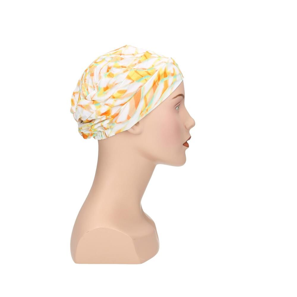 Turban mit gelb-orangem Muster auf einem Schaufensterpuppenkopf. Seitenansicht.
