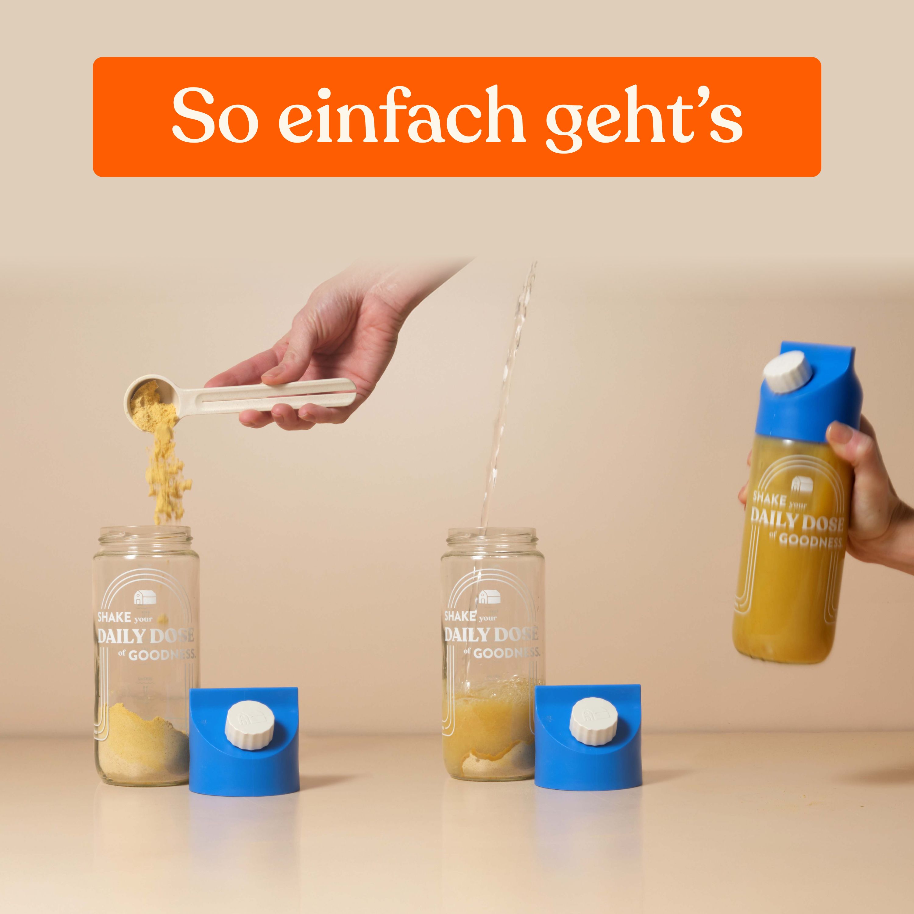 Hände füllen Behälter mit Pulver und Wasser. Blaue Deckel. Behälter mit Aufschrift: Shake Daily Goodness.