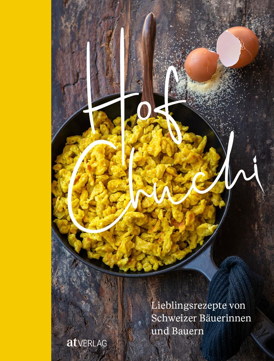 Kochbuch "Hof Chuchi" mit gelbem Inhalt in schwarzer Pfanne. Eier und Mehl daneben. Text: Lieblingsrezepte von Schweizer Bäuerinnen und Bauern.