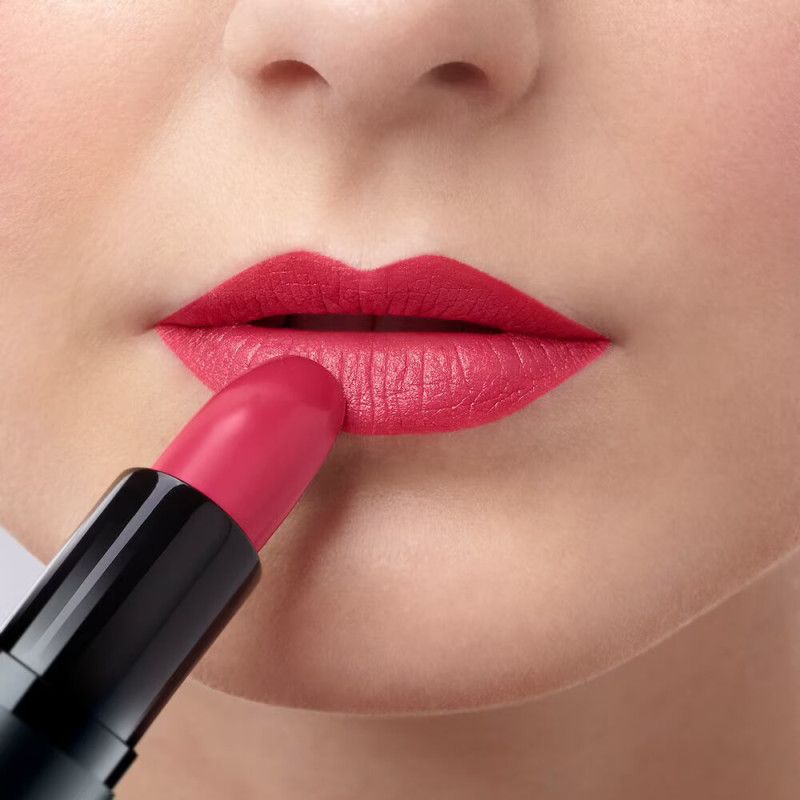 Nahaufnahme von Lippen, auf die mit einem roten Lippenstift aufgetragen wird.