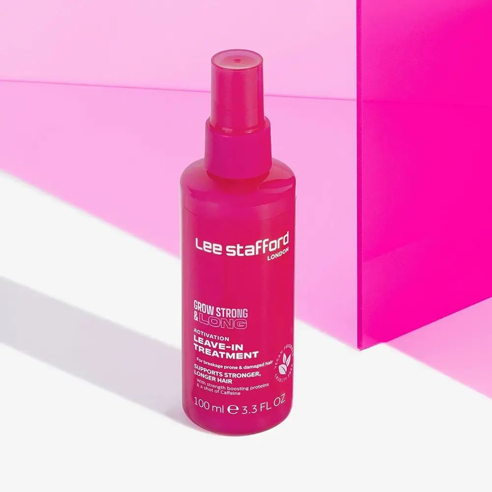 Rosa Haarspray-Flasche vor pinkem Hintergrund. Aufschrift: Lee Stafford, Grow Strong & Long, Leave-In Treatment. Vegan-Siegel.