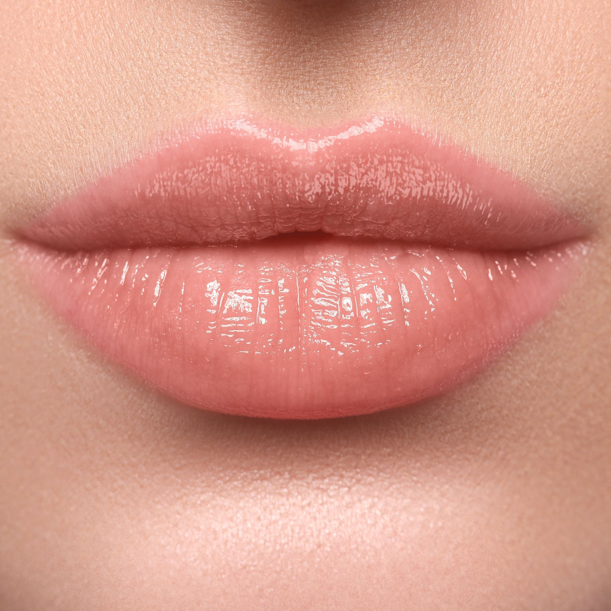 Nahaufnahme von Lippen, die mit WYCON Cosmetics Hydrasheer Glossy Lipstick in der Farbe 02 Linen geschminkt sind. Die Lippen sind glänzend und haben einen rosafarbenen Farbton.
