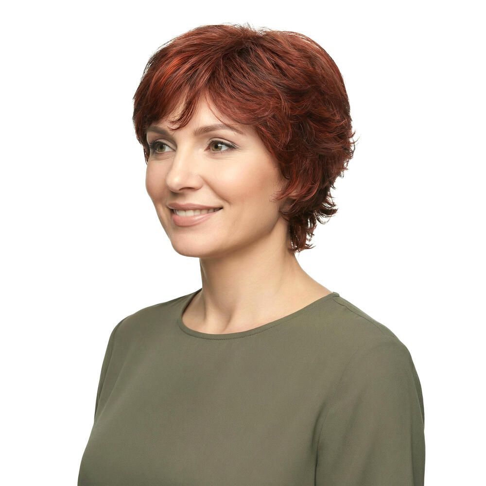 Frau mit roter Perücke. Kurzer, gewellter Haarschnitt. Seitenansicht, lächelnd.