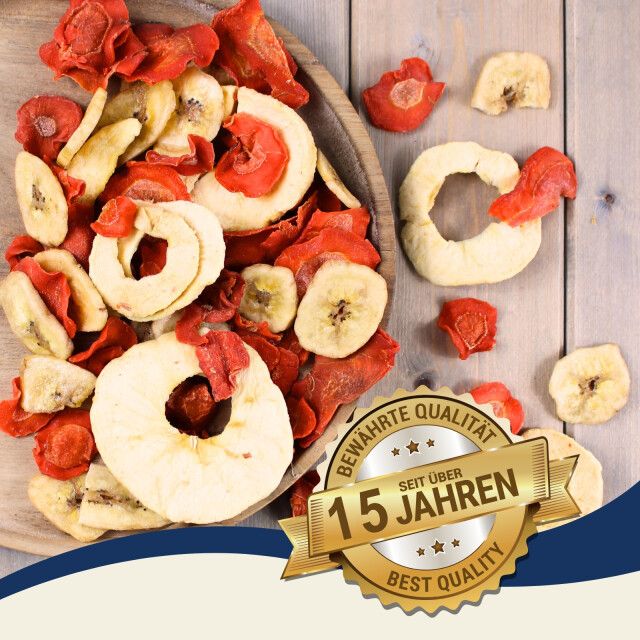 Getrocknete Obst- und Gemüsestücke in einer Holzschale. Text: 'BEWÄHRTE QUALITÄT', 'SEIT ÜBER 15 JAHREN', 'BEST QUALITY'.