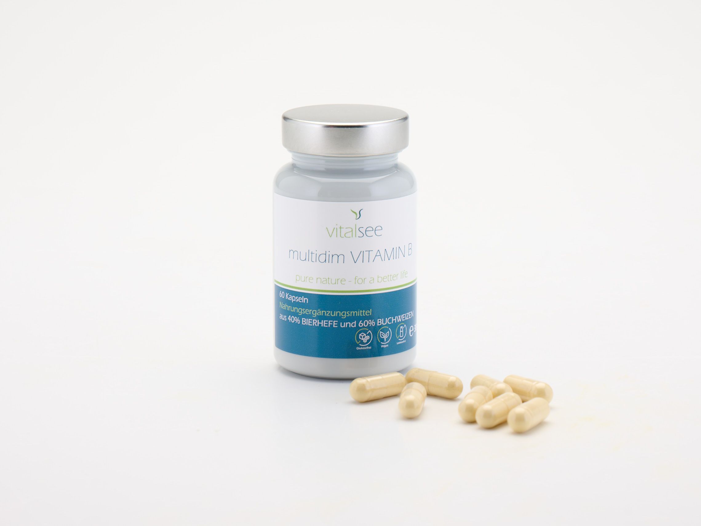 Vitalsee multidim VITAMIN B Komplex Flasche und Kapseln. Kapseln liegen daneben. Weißer Hintergrund.