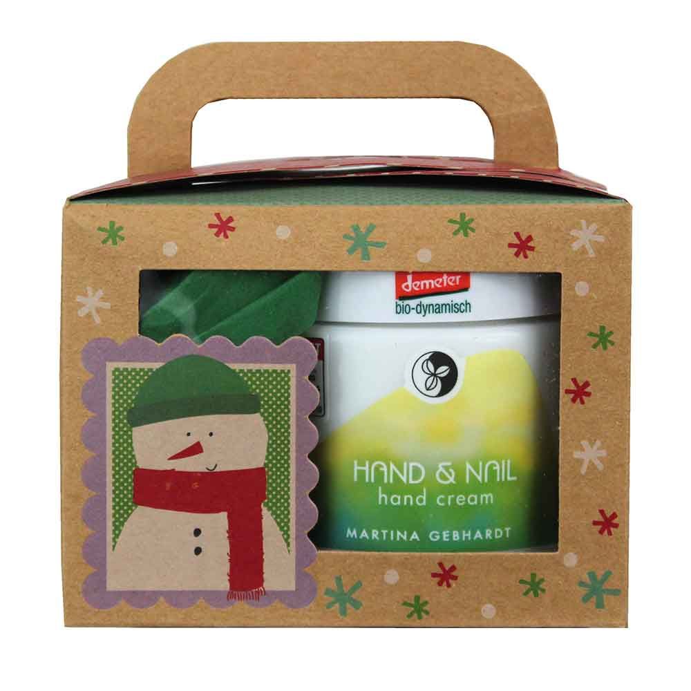 Geschenkbox mit Handcreme. Auf der Box ein Schneemann-Motiv. Sichtbar: Handcreme-Tiegel mit Aufschrift 'Hand & Nail hand cream' und 'Martina Gebhardt'.