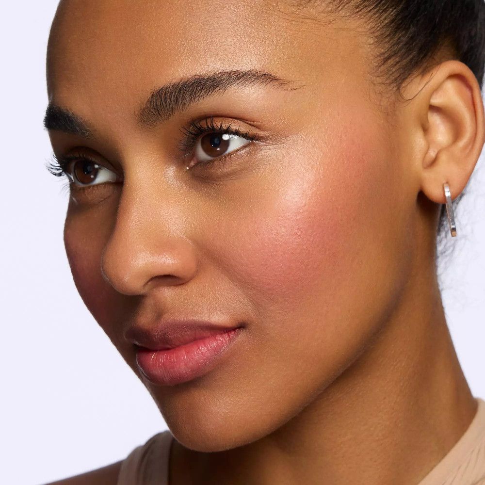 Nahaufnahme eines Gesichts mit Rouge auf den Wangen. Frau mit Ohrringen.