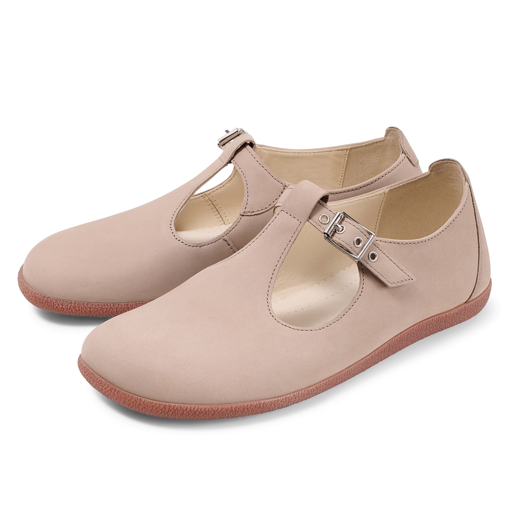 Zwei beigefarbene Slipper mit T-Riemen und Schnallen. Rote Sohle. Flaches Design.