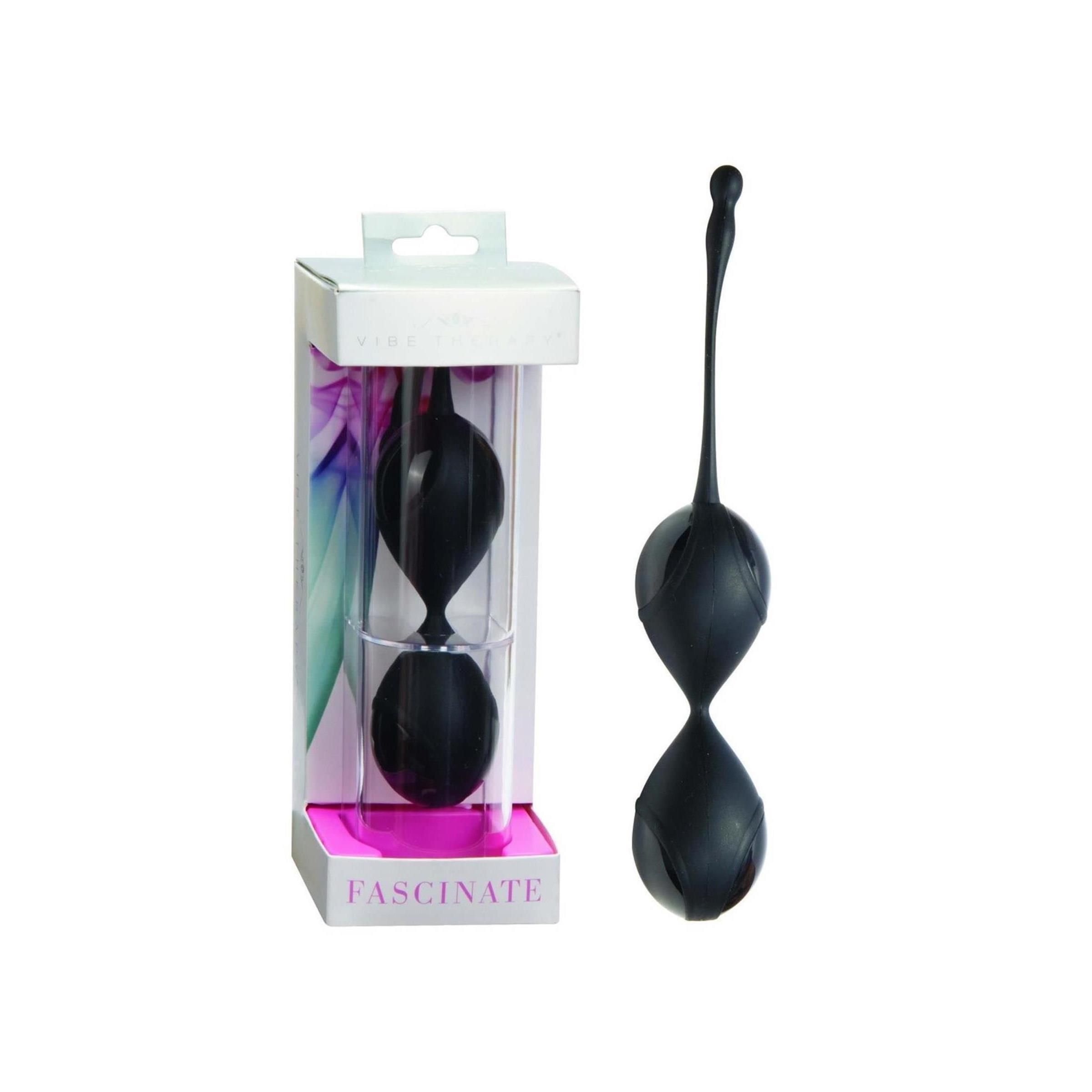 Zwei schwarze, tropfenförmige Kugeln mit Verbindungsstück und Griff. In transparenter Verpackung mit Produktnamen 'FASCINATE'.
