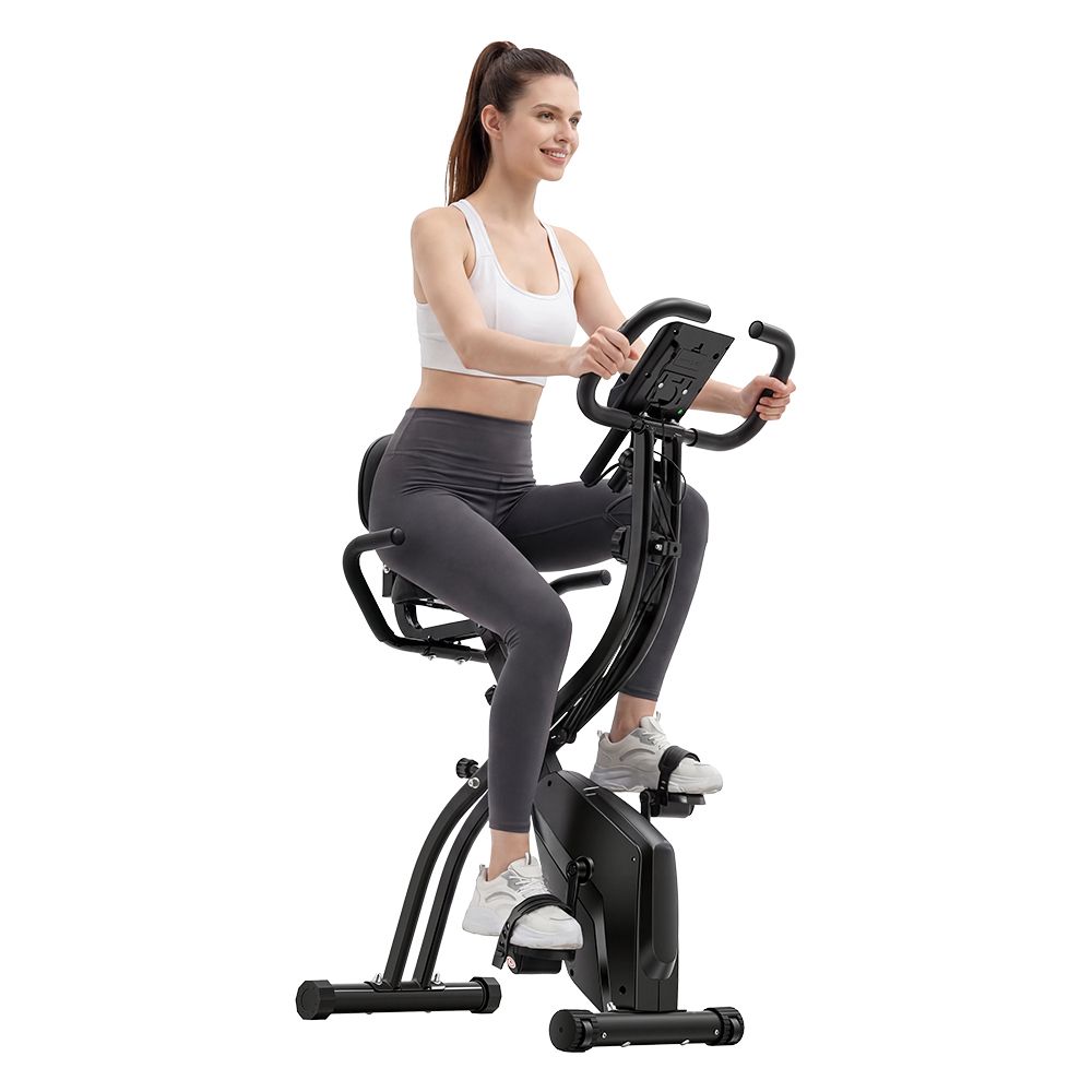Frau auf schwarzem Heimtrainer. Schwarzer Heimtrainer mit Sitz und Griffen.