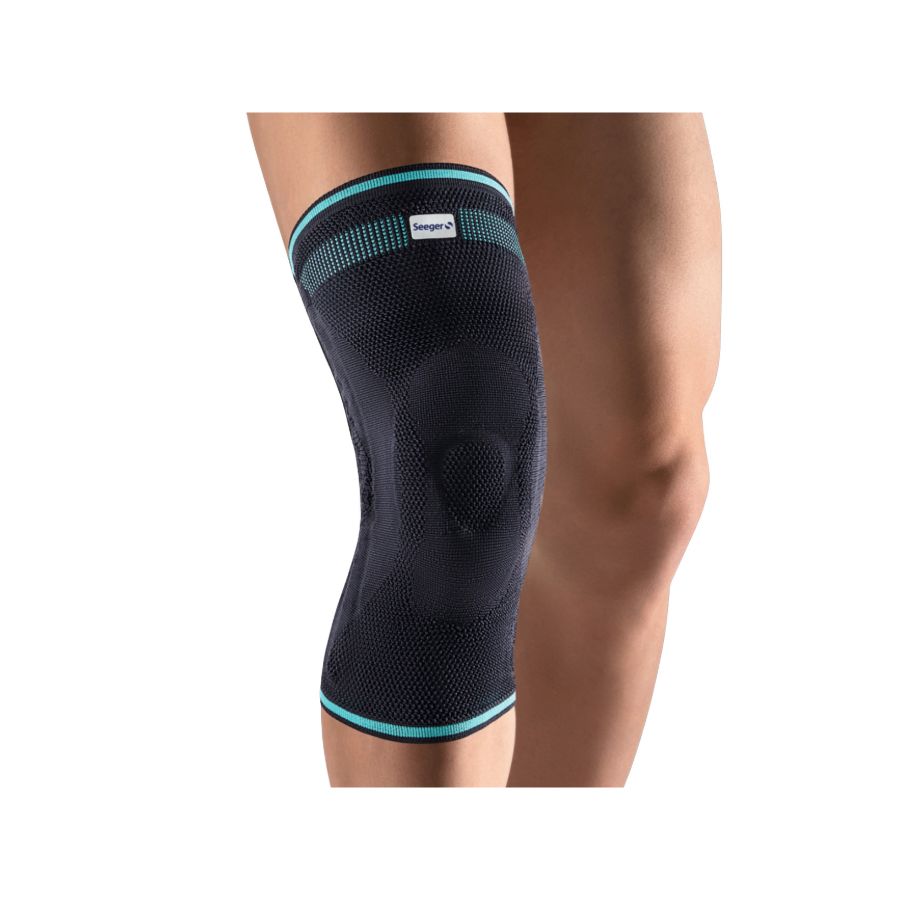 Kniebandage Komfort, dunkelblau mit türkisen Akzenten. Marke Seeger Gesundheitshaus. Auf dem Knie getragen. Elastisches Material.