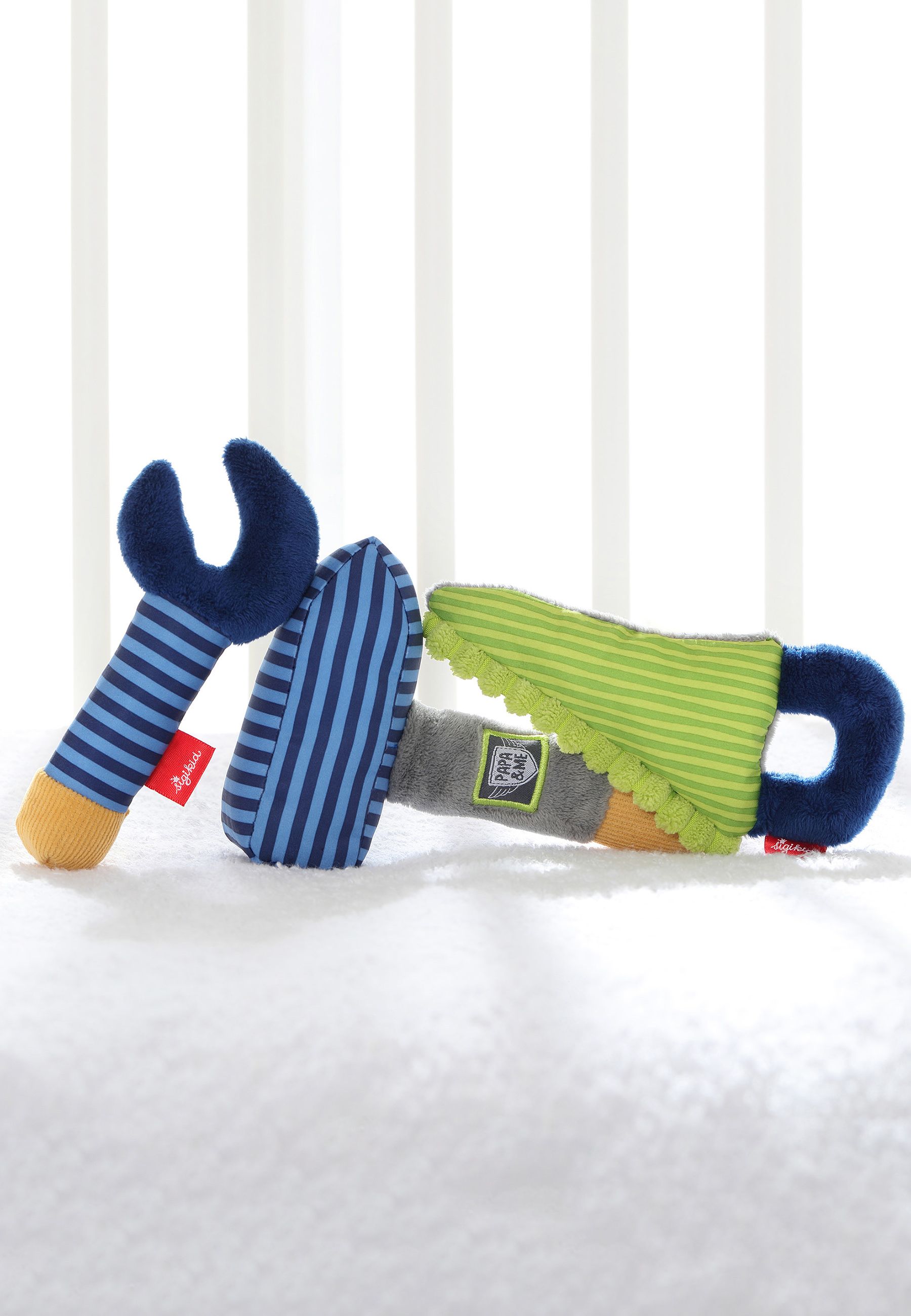 Drei Stoffwerkzeuge: Schlüssel, Hammer und Säge, auf weißem Untergrund. Sigikid-Label.