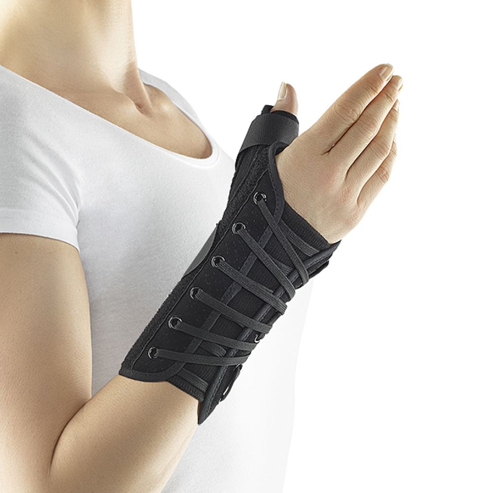 Handgelenkorthese am Handgelenk einer Person. Schwarzes Design mit Schnürung und Daumenfixierung.