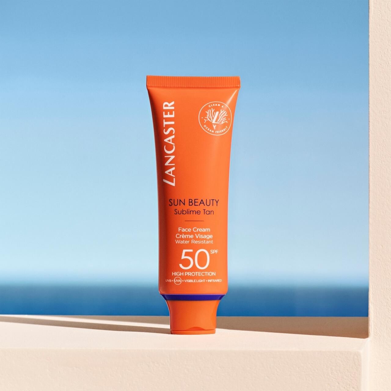 Orange Tube mit Sonnencreme vor blauem Hintergrund. Text: Lancaster, Sun Beauty, Sublime Tan, Face Cream, SPF 50.