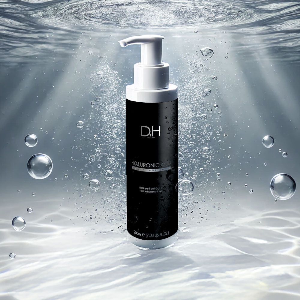 Weiße Flasche mit schwarzem Etikett unter Wasser. Aufschrift: HYALURONIC ACID, Anti-Aging. Mit Dosierpumpe. Blasen im Wasser.
