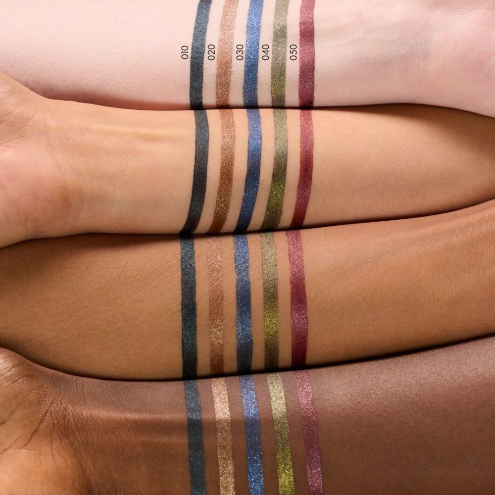 Arme mit verschiedenen Hauttönen, auf denen verschiedene Farben des Augenstifts aufgetragen sind. Beschriftung mit Farbnummern.