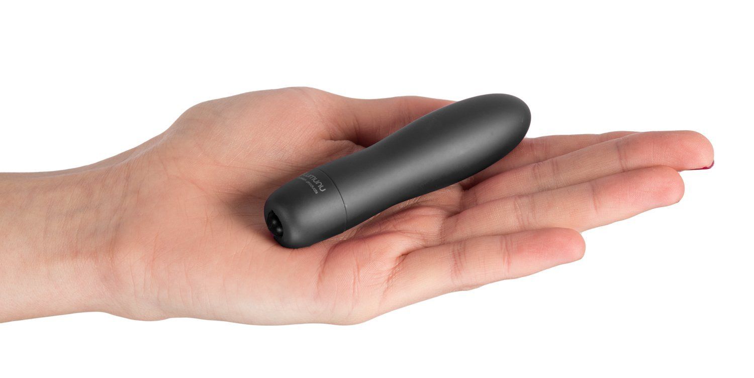 Schwarzer Minivibrator in einer Hand gehalten. Zylindrische Form mit abgerundeter Spitze.