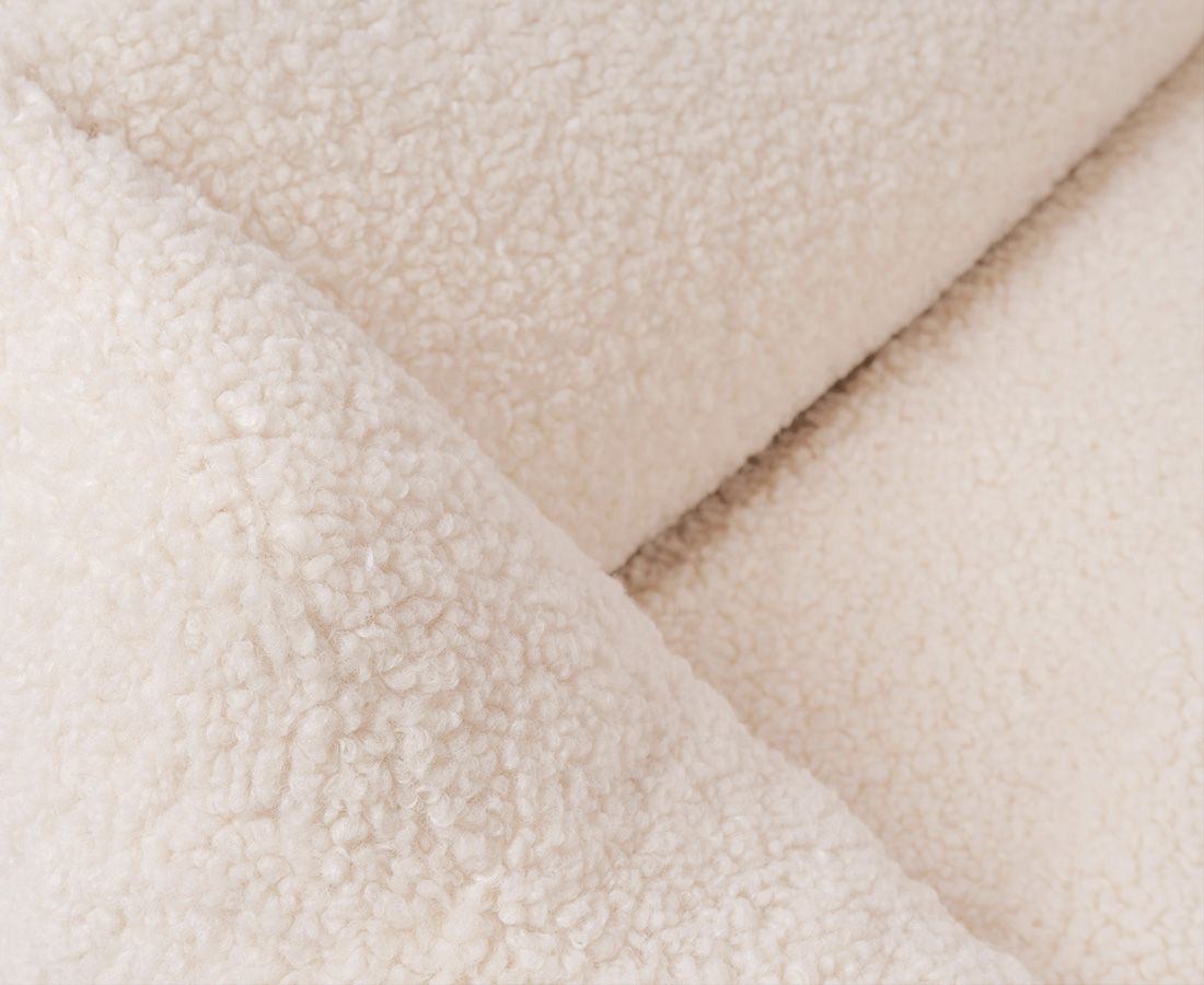 Nahaufnahme von beigem, flauschigem Material, vermutlich vom orthopädischen Hundebett.