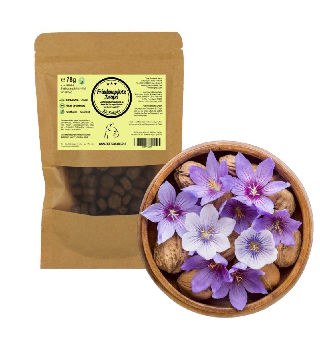 Braune Papiertüte mit Drops neben einer Holzschale mit Blüten und Walnüssen.