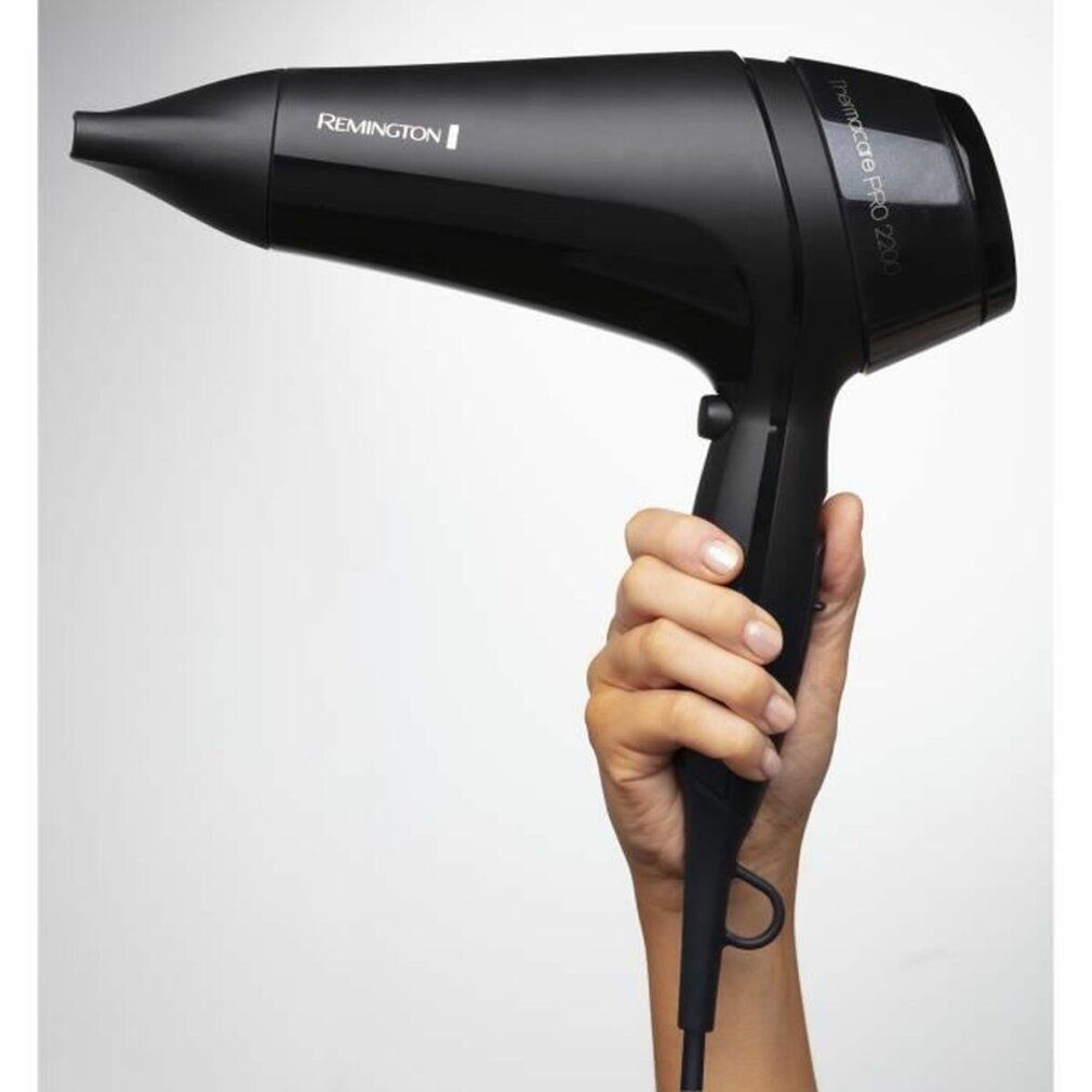 Schwarzer Haartrockner in einer Hand gehalten. Marke Remington. Modellbezeichnung auf dem Gerät.