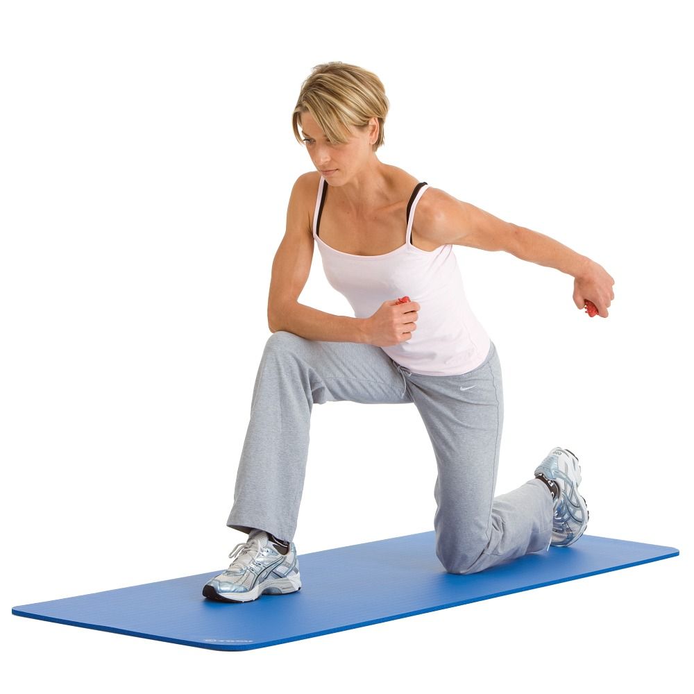 Person kniet auf einer blauen Matte und hält einen roten Togu Handtrainer. Sie trägt Sportkleidung.