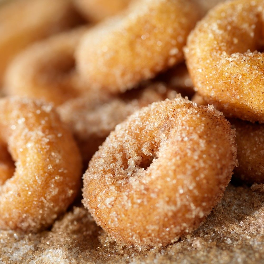 Nahaufnahme von Donuts mit Zucker. Mehrere Donuts liegen aufeinander. Goldbraune Farbe.