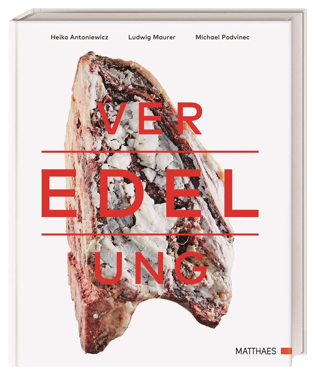 Buchcover mit rotem Schriftzug "VEREDELUNG" über einem Fleischstück. Autorennamen und Verlagslogo sind ebenfalls sichtbar.