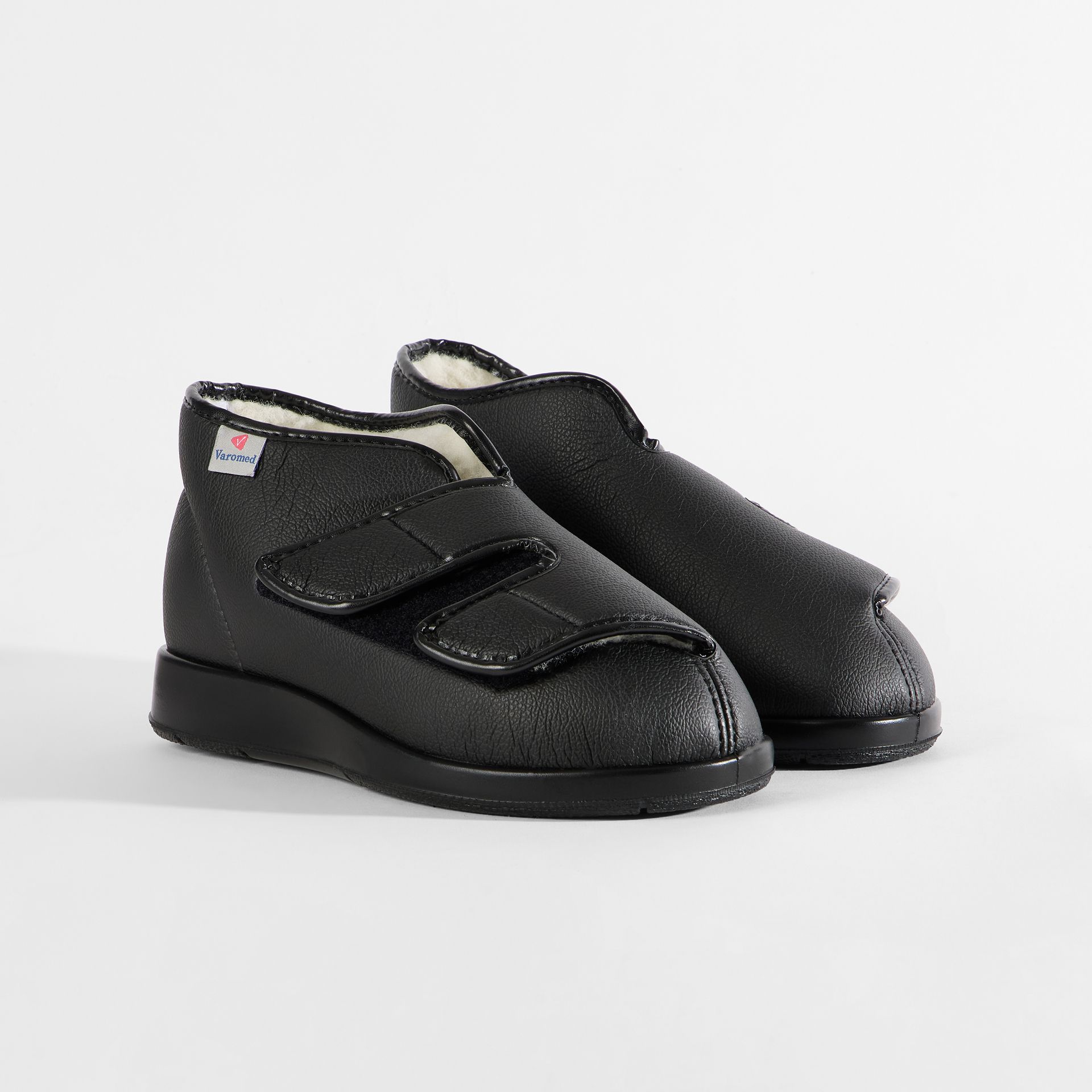 Schwarze Hausschuhe mit Klettverschluss und Teddyfutter.