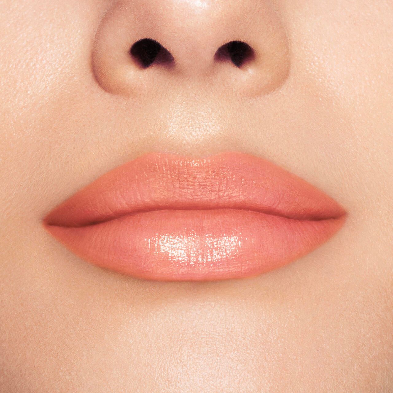 Nahaufnahme von Lippen mit pfirsichfarbenem Lippenbalsam. Hautton.