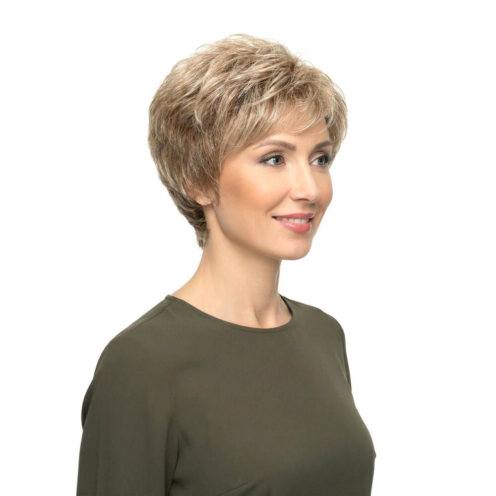 Kurzhaarperücke in Blondtönen. Seitenansicht einer Frau mit Perücke und grünem Oberteil. Weißer Hintergrund.