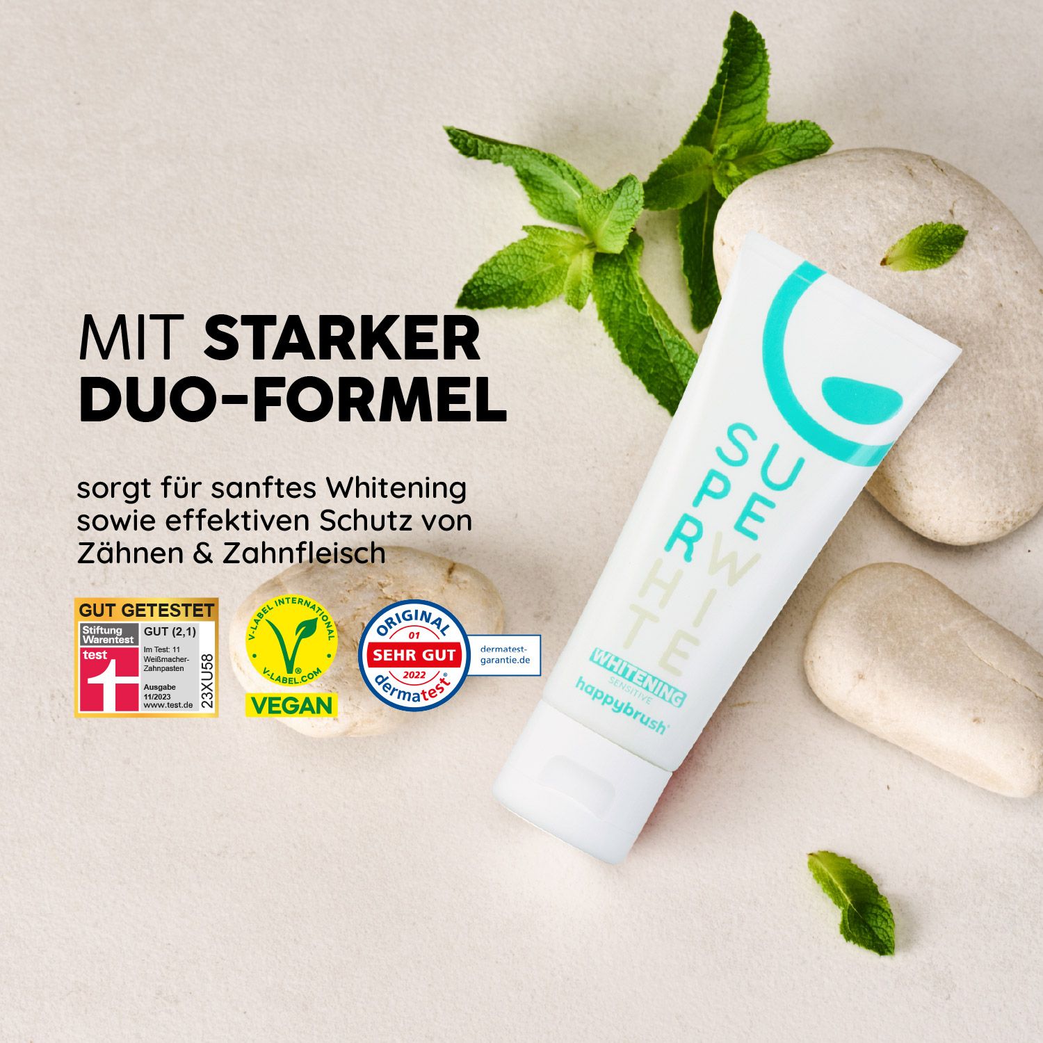 Zahnpasta-Tube mit Minze und Steinen. Aufschrift: Super White, happybrush. Siegel: Vegan, Original Dermatest, Gut getestet.