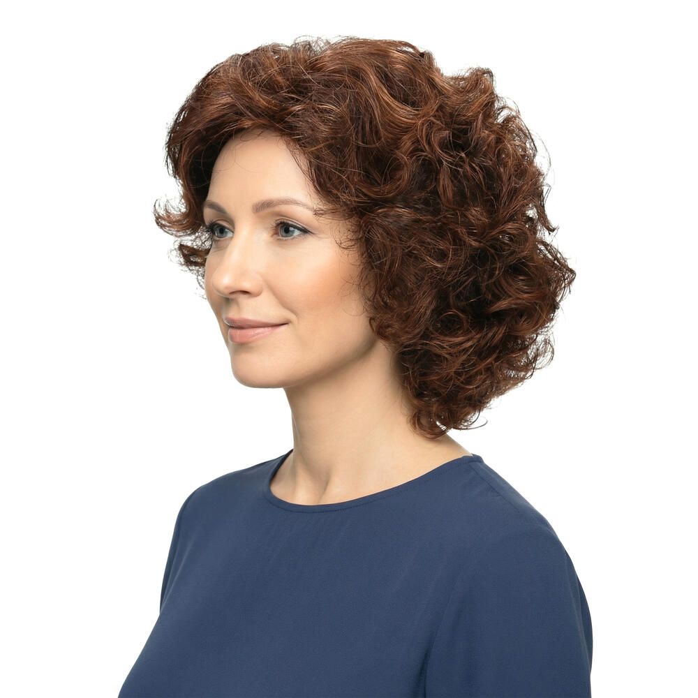 Frau mit brauner Perücke mit Locken, Seitenansicht. Sie trägt ein blaues Oberteil. Weißer Hintergrund.