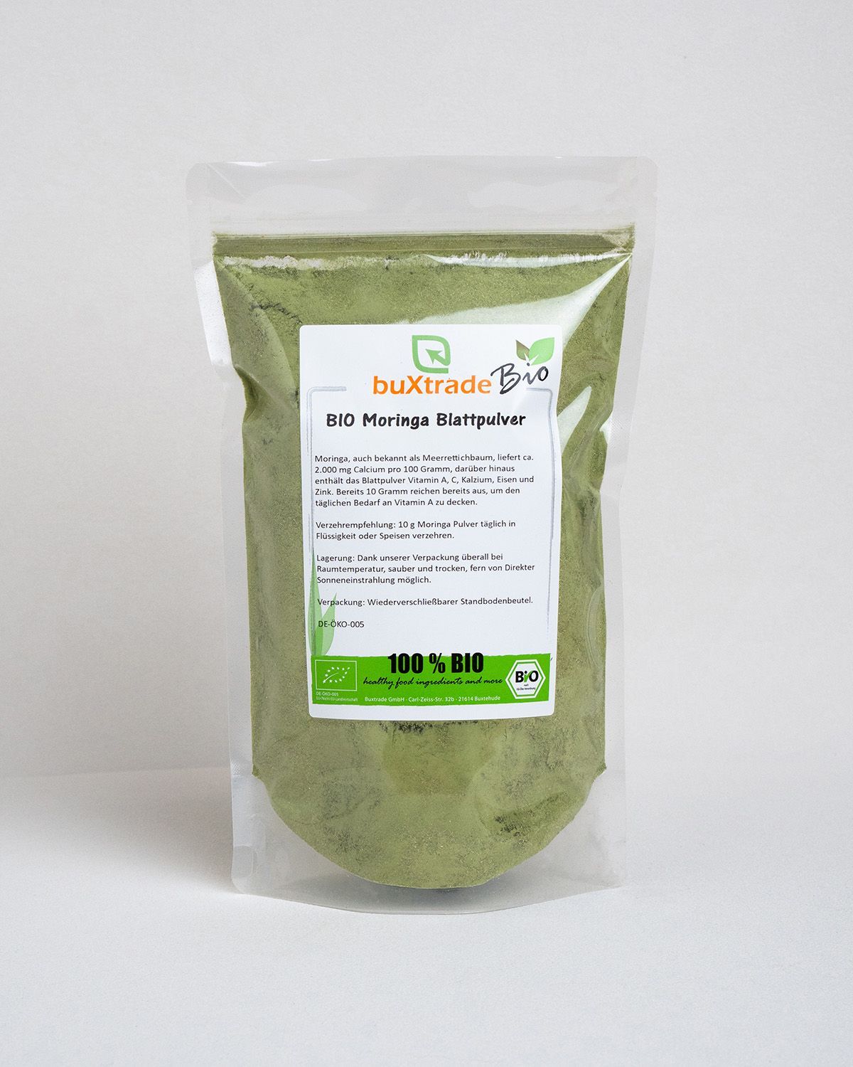 Transparente Plastiktüte mit grünem Pulver. Aufschrift: buXtrade Bio Moringa Blattpulver. Bio-Siegel.