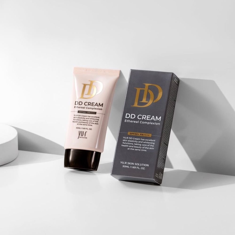 Rosa Tube und Schachtel. Aufschrift: DD CREAM Ethereal Complexion. Marke: Yu.r Skin Solution. Schwarze Schrift auf grauem Hintergrund.