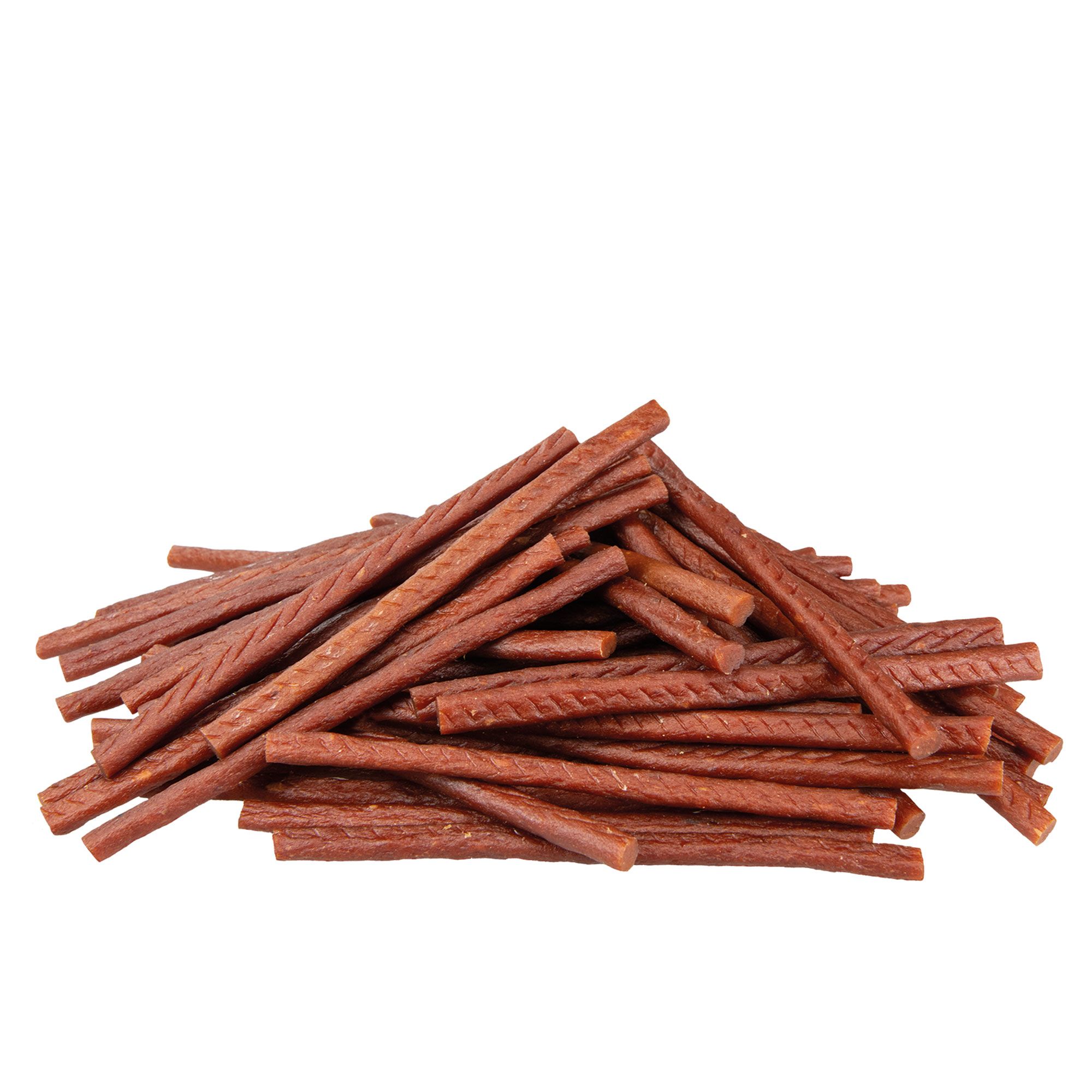 Haufen brauner, stäbchenförmiger Hundesnacks mit geriffelter Oberfläche. Auf weißem Hintergrund.