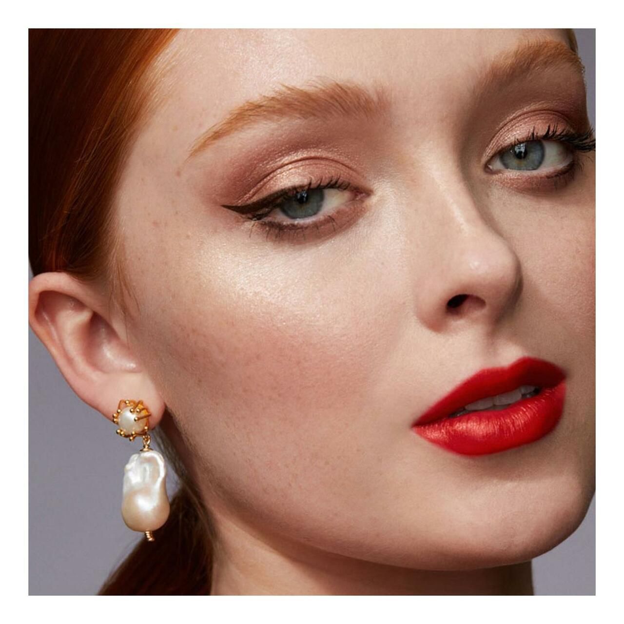 Nahaufnahme eines Gesichts mit Make-up. Roter Lippenstift, Eyeliner, Lidschatten.