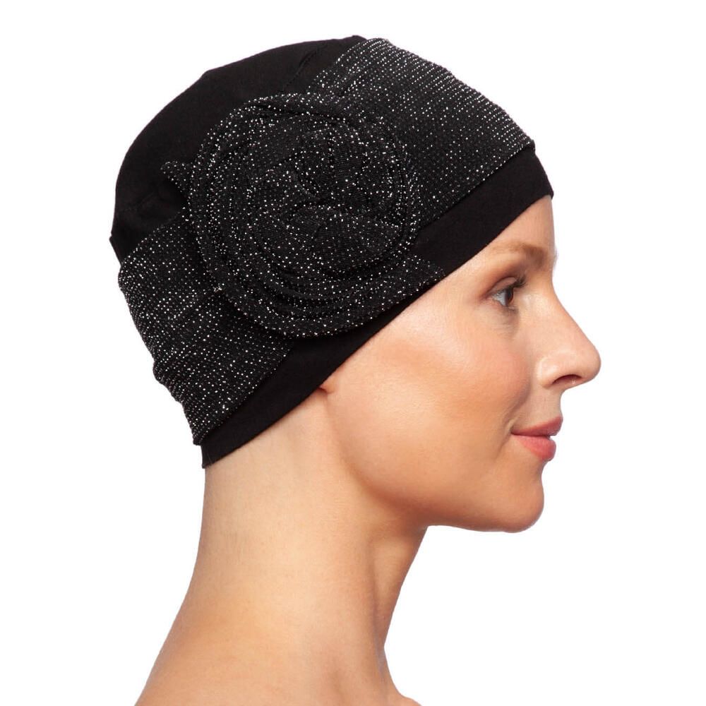 Schwarzer Turban mit glitzernder Blüte. Seitenansicht auf einer Frau.