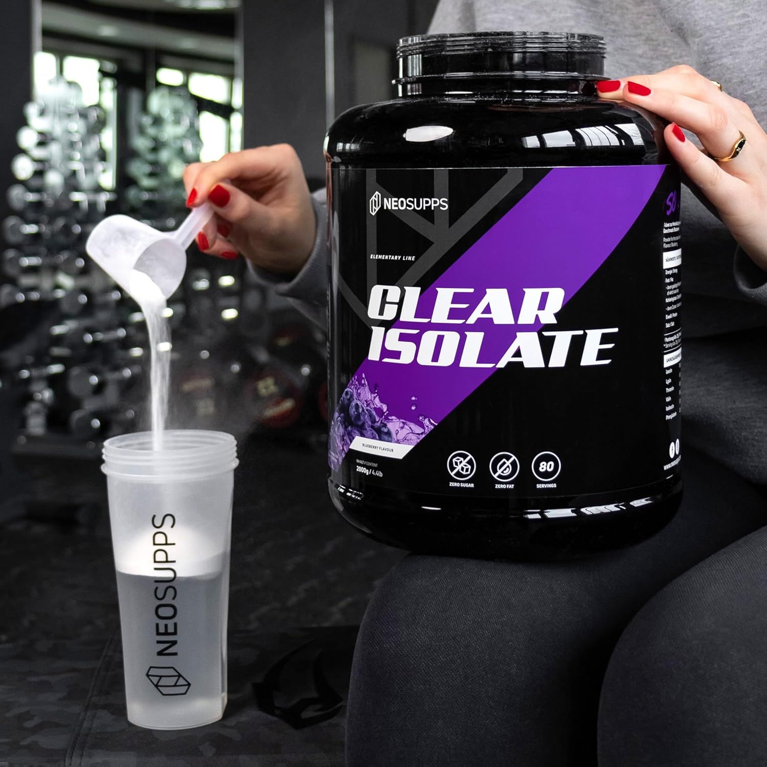 Person gibt Neosupps Clear Isolate Protein Pulver in einen Shaker mit Wasser.