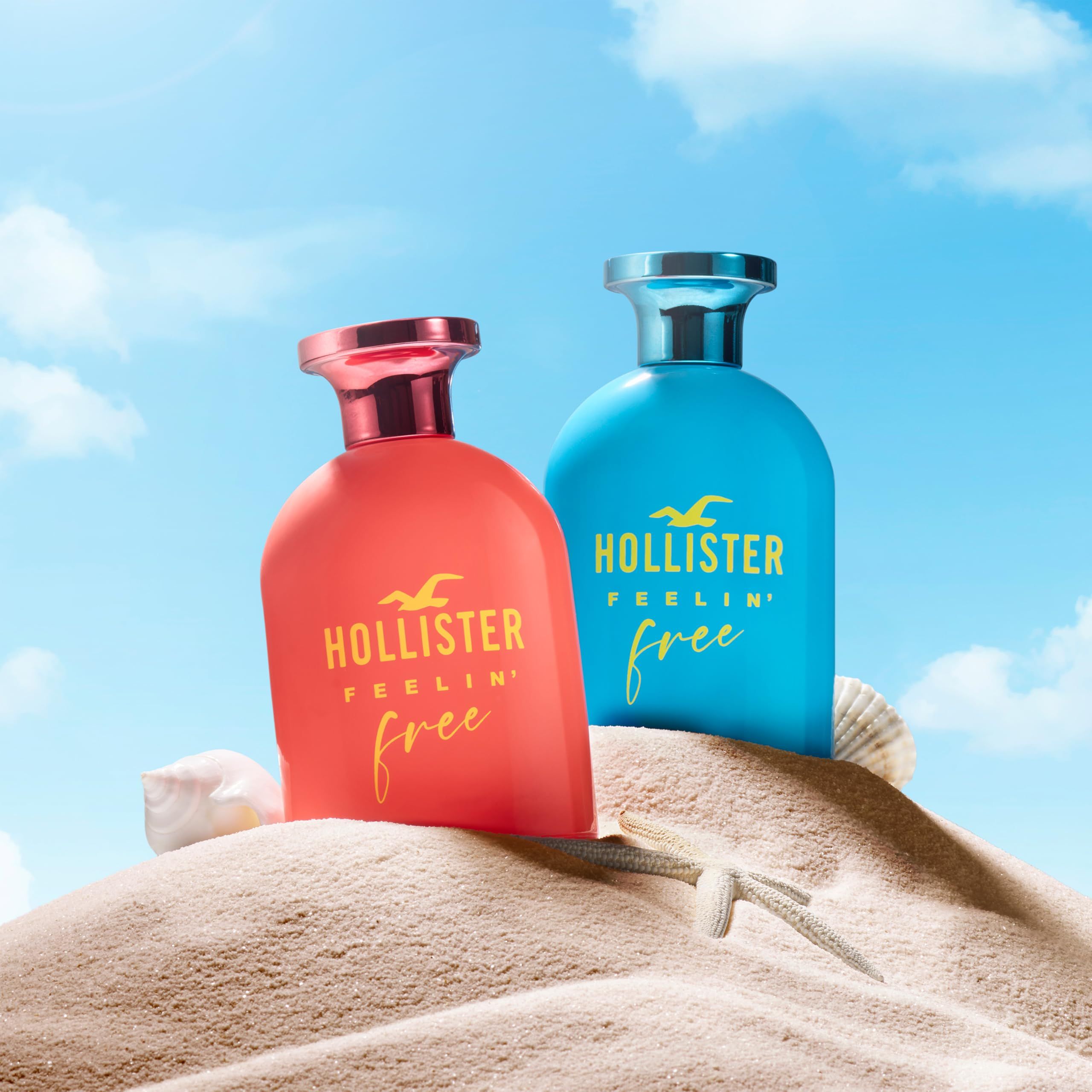 Zwei Flakons auf Sand. Aufschrift: Hollister Feelin' Free. Rosa und blauer Verschluss. Hintergrund: Sand.
